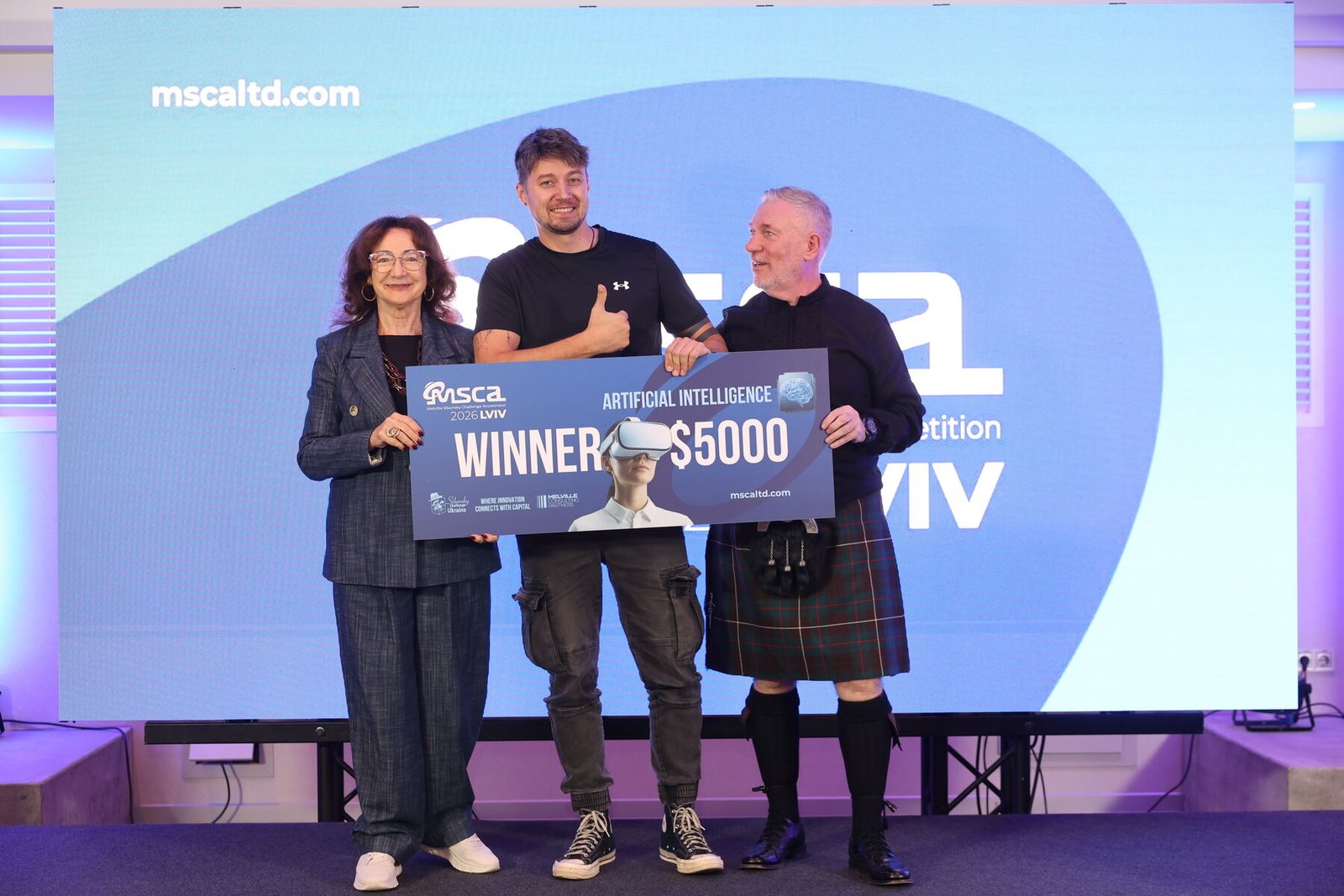 The Skadi founder holds the Artificial Intelligence winner cheque for $5,000 on stage with Stuart Ford